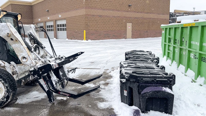 Skid loader with Virnig Salt Spreader picking up SiteTote container